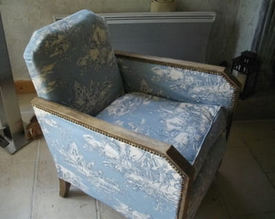 un vieux fauteuil recouvert de toile de jouy